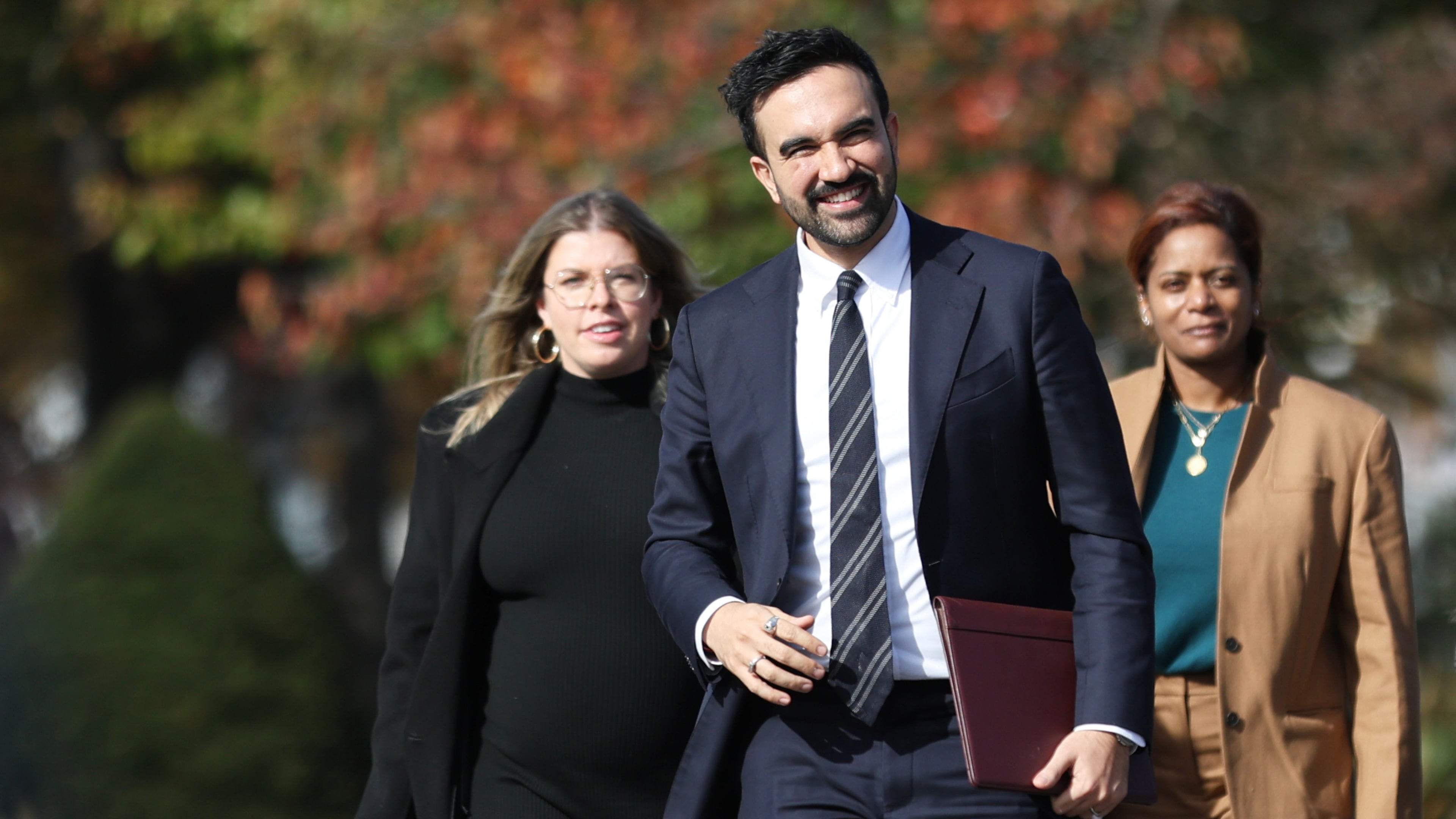 New York City mayor-elect Zohran Mamdani, center, walks with members of his transition team including Elana Leopold, left, and Melanie Hartzog for a news conference in the Queens borough of New York, Wednesday, Nov. 5, 2025. (AP Photo/Heather Khalifa)