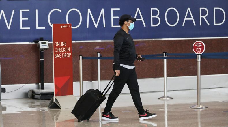 A masked passenger walks through the check-in area at Hartsfield-Jackson Airport's South Terminal on Tuesday, June 23, 2020. Miguel Martinez for The Atlanta Journal-Constitution