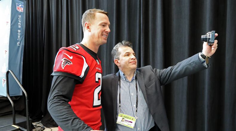 A tip to all you kids in J school - under no circumstances do this after an interview session. You're not there to take selfies with the quarterback. (Curtis Compton/ccompton@ajc.com)