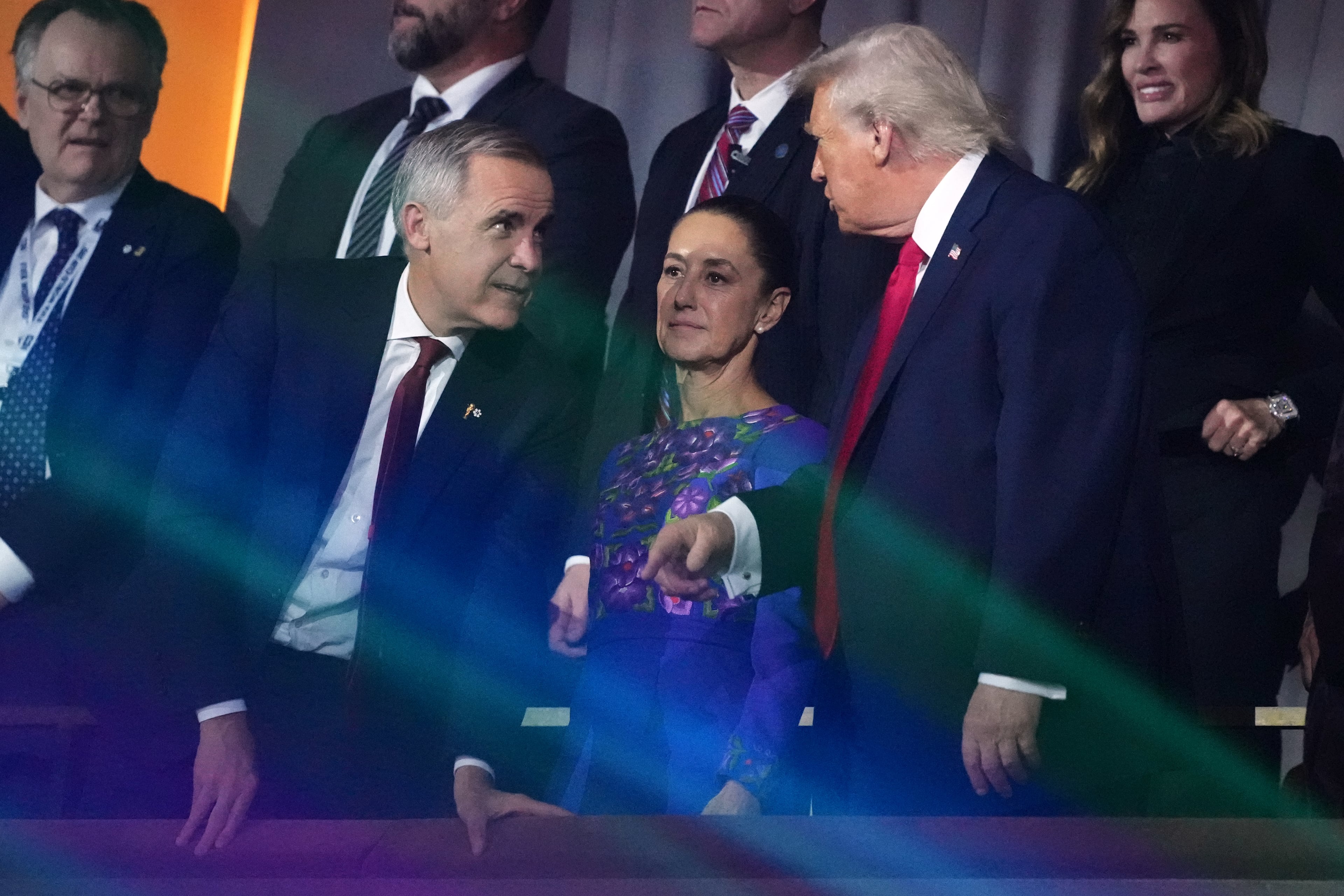 President Donald Trump speaks to Canadian Prime Minister Mark Carney as Mexican President Claudia Sheinbaum looks on at the end of the draw for the 2026 soccer World Cup at the Kennedy Center in Washington, Friday, Dec. 5, 2025. (AP Photo/Stephanie Scarbrough, Pool)