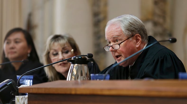 FILE- In this Sept. 18, 2014, file photo, Circuit Judge William A. Fletcher, right, questions Asst. U.S. Atty. Merry Chan about Barry Bonds' conviction before an 11-judge panel of the 9th U.S. Circuit Court of Appeals in San Francisco. The federal appellate court is hearing arguments whether to reinstate President Donald Trump's immigration travel ban. (AP Photo/Eric Risberg, Pool, File)