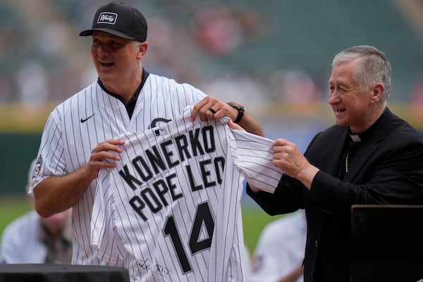 Cardinal Blase Cupich, right, presents former White Sox player Paul Konerko with a jersey signed by Pope Leo XIV during a ceremony honoring the 2005 World Series Champions before a baseball game between the Cleveland Guardians and Chicago White Sox, Saturday, July 12, 2025, in Chicago. (AP Photo/Erin Hooley)