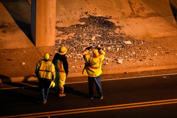 A pile of concrete rubble is visible on Meadowbrook Lane below a pothole that opened on I-75 North in Morrow early Wednesday. (Ben Hendren for the AJC)