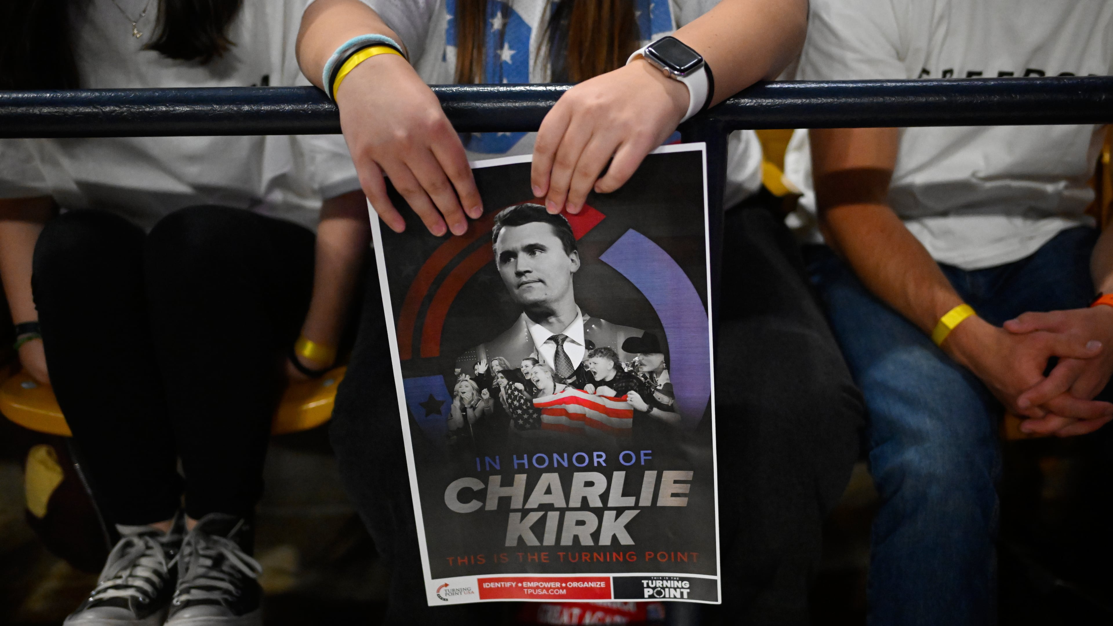 An attendee holds a poster of Charlie Kirk at a Turning Point USA rally at Utah State University, as a part of the organization's push to memorialize Kirk, Tuesday, Sept. 30, 2025, in Logan, Utah. (AP Photo/Alex Goodlett)