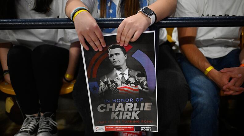 An attendee holds a poster of Charlie Kirk at a Turning Point USA rally at Utah State University, as a part of the organization's push to memorialize Kirk, Tuesday, Sept. 30, 2025, in Logan, Utah. (AP Photo/Alex Goodlett)