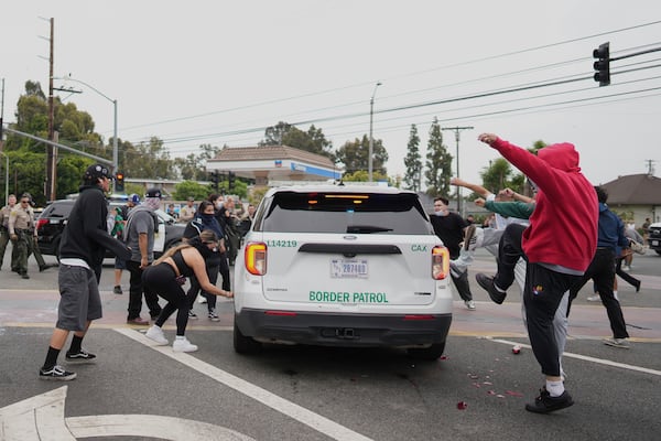 Protesters kick the side of a Border Patrol vehicle in the Paramount section of Los Angeles on Saturday, June 7, 2025 (AP Photo/Eric Thayer)