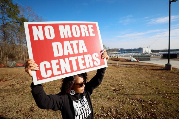 Advocate and activist Wanda Mosley of South Fulton holds signs protesting the Microsoft data center in Union City on Wednesday, Dec. 3, 2025. (Miguel Martinez/AJC)