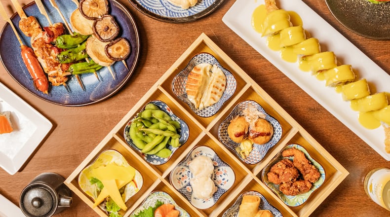 An overhead view of a variety of Japanese food items spread out on a table and filling the image frame
