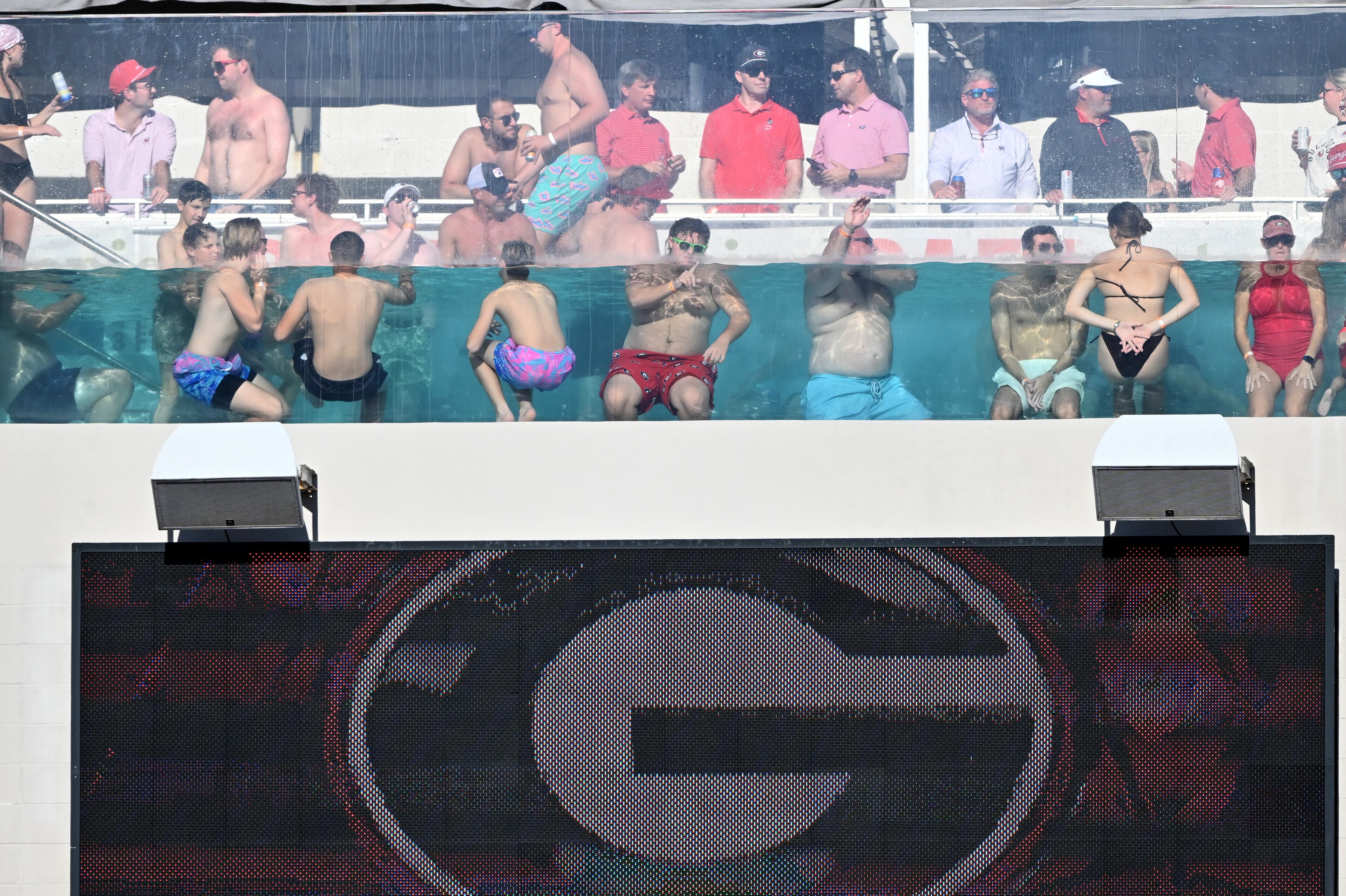 Football fans enjoy watching from a swimming pool during the first half in an NCAA football game, Saturday, November 1, 2025, Jacksonville, Fla. (Hyosub Shin / AJC)