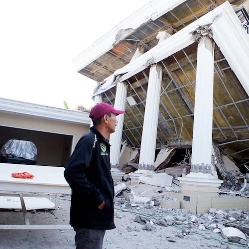 A man examines a building that collapsed during an earthquake in Reo, East Nusa Tenggara province, Indonesia, Monday, Aug. 17, 2026. (AP Photo/Firdia Lisnawati)
