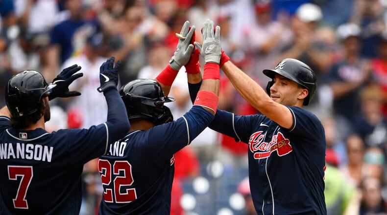 Atlanta Braves' Matt Olson, right, celebrates his three-run home run with Robinson Cano (22) and Dansby Swanson (7) during the third inning of a baseball game against the Washington Nationals, Saturday, July 16, 2022, in Washington. (AP Photo/Nick Wass)