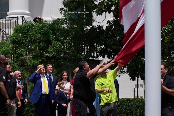 President Donald Trump salutes as a flag is raised on the South Lawn of the White House, Wednesday, June 18, 2025, in Washington. (AP Photo/Evan Vucci)