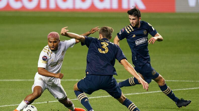 Atlanta United's Josef Martinez, left, battles with Philadelphia Union's Jack Elliott, center, for the ball as Philadelphia Union's Leon Flach, right, looks on during the first half of a CONCACAF Champions League soccer match, Tuesday, May 4, 2021, in Chester, Pa. (AP Photo/Chris Szagola)