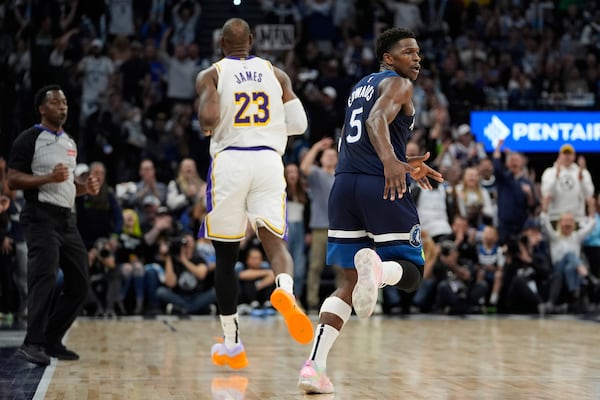 Minnesota Timberwolves guard Anthony Edwards (5) celebrates next to Los Angeles Lakers forward LeBron James (23) after making a 3-point shot during the first half of Game 4 of an NBA basketball first-round playoff series, Sunday, April 27, 2025, in Minneapolis. (AP Photo/Abbie Parr)