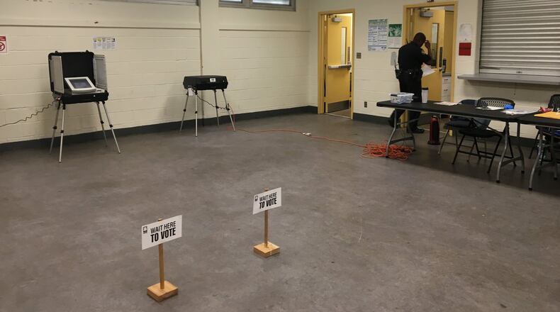 An Atlanta police officer examines the area where two voter check-in computers were stolen the night before an Atlanta school board election Tuesday. MARK NIESSE / MARK.NIESSE@AJC.COM