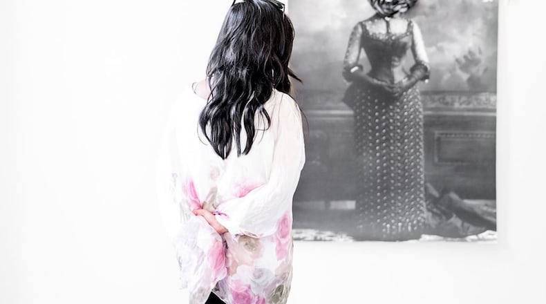 A woman contemplates Atlanta artist Yanique Norman’s mixed media work “I Marched Through Your Gardens So That I Can Devour Your Weeds” (2018).Contributed by the artist. Photo by Terrell Clark