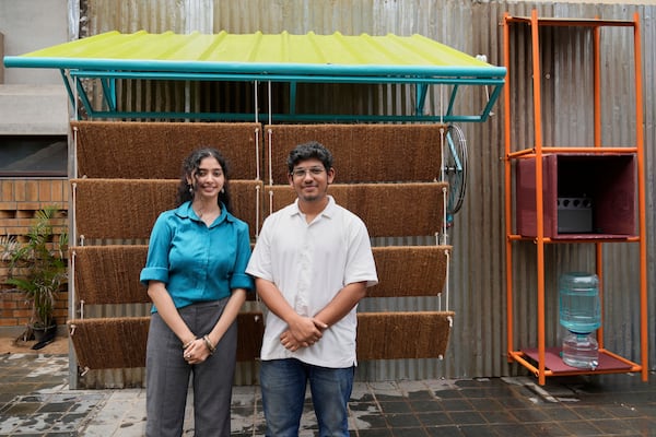 Ankritya Diggavi, left, and Sagar Kandal, architects behind the design of Neralu, an innovative portable heat shelter, pose in front of their installation at the Sweat and Concrete 2025 event in Bengaluru, India, Thursday, May 29, 2025. (AP Photo/Aijaz Rahi)