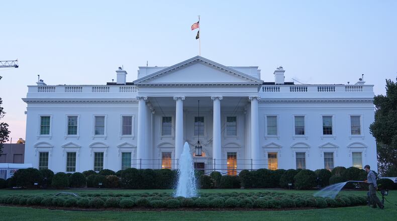 A worker waters plants on the North Lawn of the White House Monday, Sept. 21, 2026, in Washington. (AP Photo/Mark Schiefelbein)