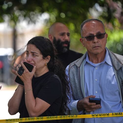 People stand behind police tape at the scene of a shooting outside the Islamic Center of San Diego Monday, May 18, 2026, in San Diego. (AP Photo/Gregory Bull)