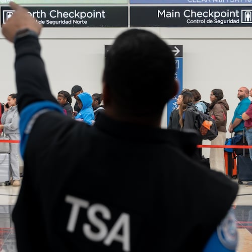 A Transportation Security Administration officer helps a traveler find the right security line at Hartsfield-Jackson Atlanta International Airport on Monday, March 9, 2026. (Ben Hendren for the AJC)
