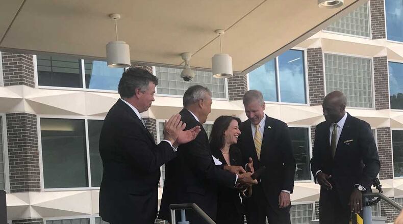 Georgia Tech Research Institute interim director Lora Weiss (center) shares a laugh after a ribbon-cutting ceremony to mark the opening of a new facility in Cobb County. About 500 employees are expected to conduct research in the four building complex, which had been owned by Lockheed Martin. ERIC STIRGUS / ESTIRGUS@AJC.COM