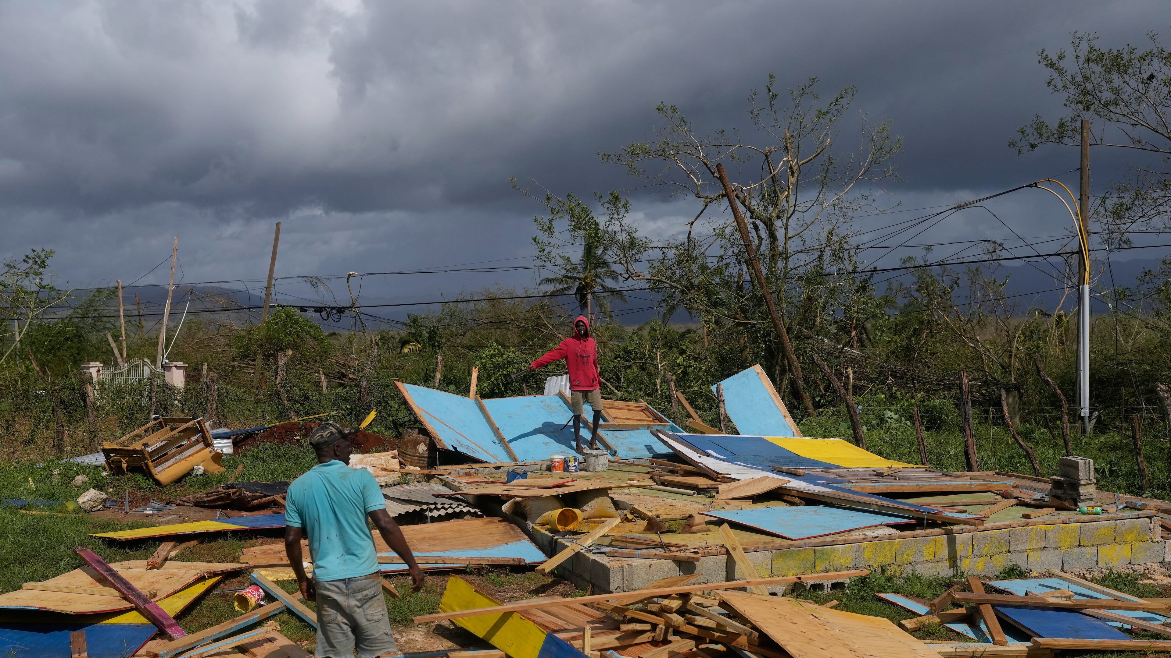 Residents stand on the wreckage of a house destroyed by Hurricane Melissa in Santa Cruz, Jamaica, Wednesday, Oct. 29, 2025. (AP Photo/Matias Delacroix)