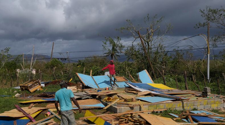 Residents stand on the wreckage of a house destroyed by Hurricane Melissa in Santa Cruz, Jamaica, Wednesday, Oct. 29, 2025. (AP Photo/Matias Delacroix)