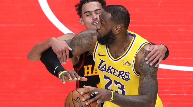 Hawks guard Trae Young fouls Lakers forward LeBron James in the final seconds of a 107-99 loss to the Lakers Monday, Feb.1, 2021, at State Farm Arena in Atlanta.  (Curtis Compton / Curtis.Compton@ajc.com)