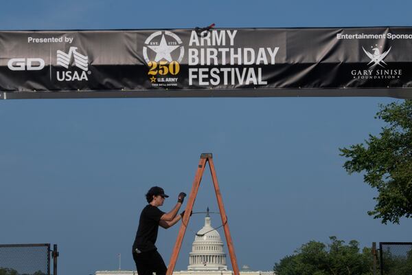Crews work on setting up an archway on the National Mall, during preparations for an upcoming military parade commemorating the Army's 250th anniversary and coinciding with President Donald Trump's 79th birthday, Thursday, June 12, 2025, in Washington. (AP Photo/Rod Lamkey, Jr.)