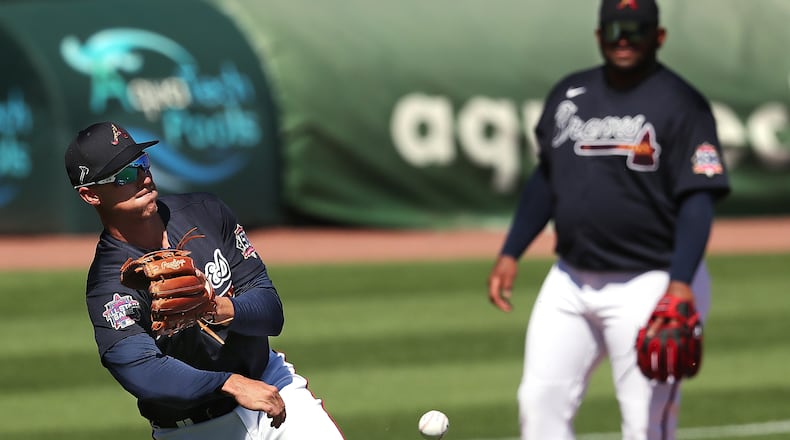 Atlanta Braves third baseman Jake Lamb fields a grounder with Pablo Sandoval looking on during the first full squad workout Tuesday, Feb. 23, 2021, at CoolToday Park in North Port, Fla. Lamb signed a $1 million non-guaranteed, major-league deal for the 2021 season. (Curtis Compton / Curtis.Compton@ajc.com)
