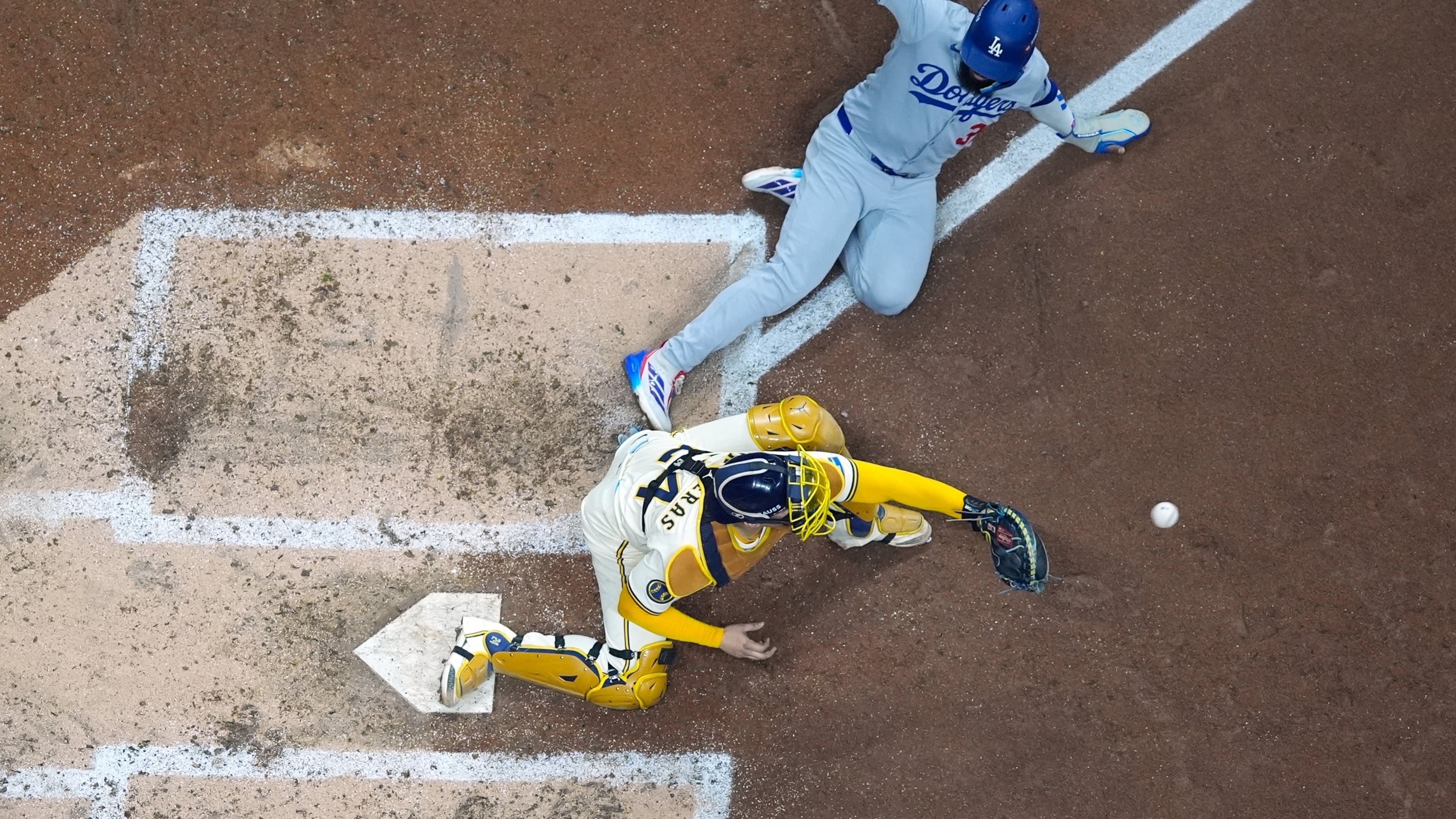 Los Angeles Dodgers' Teoscar Hernández is out at home as Milwaukee Brewers catcher William Contreras takes the throw during the fourth inning of Game 1 of baseball's National League Championship Series Monday, Oct. 13, 2025, in Milwaukee. (AP Photo/Morry Gash)