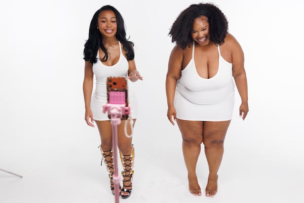 Entrepreneur and influencer Jayda Cheaves, left, and model Omeshia Ferguson, right, make a TikTok in the middle of a photo shoot for the new Waydamin clothing line, Friday, May 29, 2026 in Atlanta. Cheaves has 4.7 million TikTok followers. (Estela Muñoz/AJC)