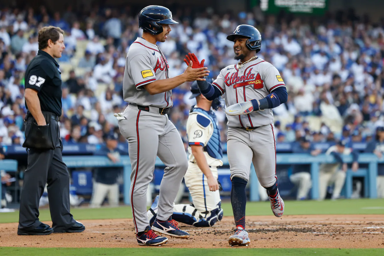 Atlanta Braves designated hitter Drake Baldwin, center left, greets teammate Ozzie Albies, center right, after they scored off a single hit by Braves' Matt Olson (not shown) during the second inning of a baseball game against the Los Angeles Dodgers, Saturday, May 9, 2026, in Los Angeles. (AP Photo/Caroline Brehman)