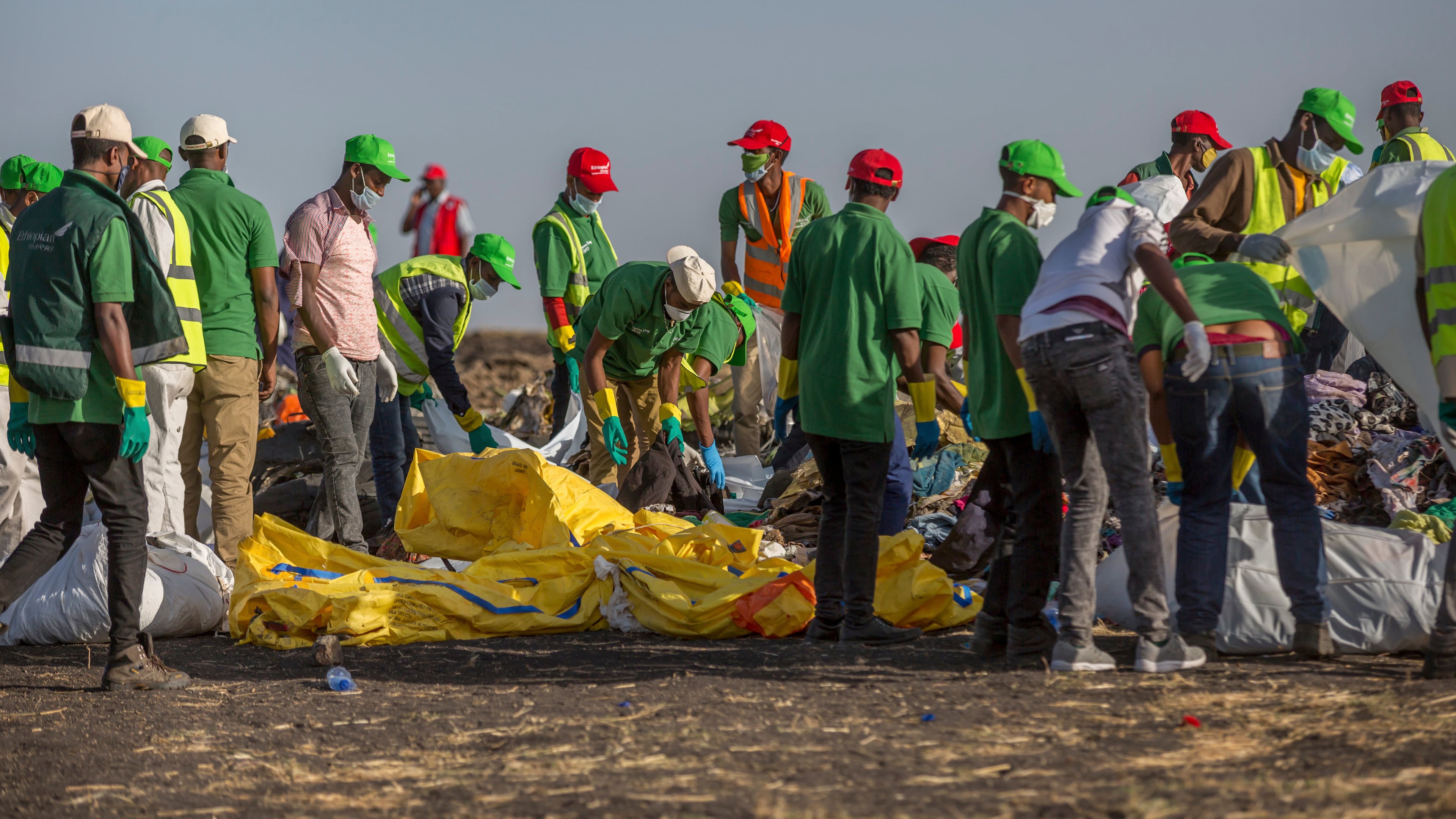 FILE - Workers collect debris on March 12, 2019 at the scene where an Ethiopian Airlines Boeing 737 Max 8 crashed shortly after takeoff, killing all 157 on board, near Bishoftu, or Debre Zeit, south of Addis Ababa, in Ethiopia. (AP Photo/Mulugeta Ayene, File)