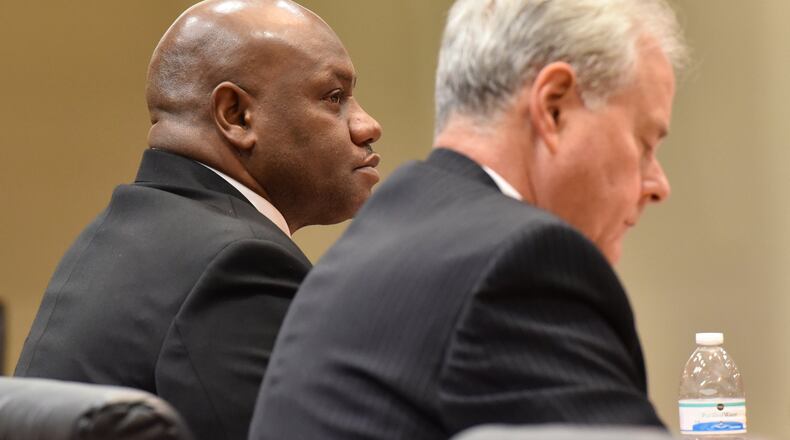 Former DeKalb Police Sgt. Anthony Remone Robinson, left, listens to testimony against him on Feb. 18, 2016. Robinson stood accused of ordering suspects to be beaten. On Friday, Feb. 26, he was found guilty on six counts but avoided conviction on the most serious charges. BRANT SANDERLIN/BSANDERLIN@AJC.COM