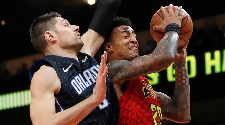 Atlanta Hawks forward John Collins goes up for a basket as Orlando Magic center Nikola Vucevic defends during the first half Sunday, Feb. 10, 2019, in Atlanta.