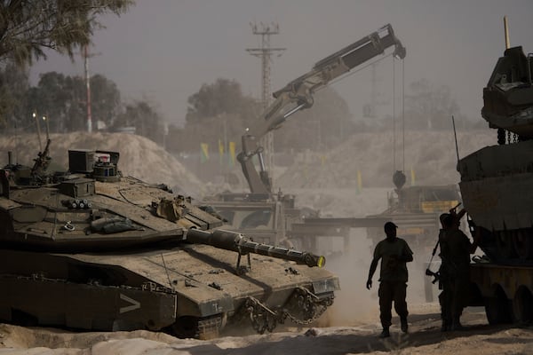 Israeli soldiers work on tanks at a staging area near the border with the Gaza Strip, in southern Israel, Tuesday, July 1, 2025. (AP Photo/Ariel Schalit)
