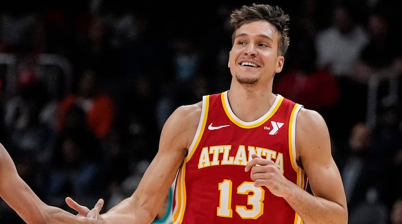 Atlanta Hawks guard Bogdan Bogdanovic (13) celebrates his three-point shot against the Charlotte Hornets during the first half of an NBA basketball game, Wednesday, April 10, 2024, in Atlanta. (AP Photo/Mike Stewart)
