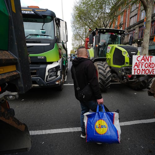 A man walks in between vehicles parked on O'Connell Street on the second day of a national fuel protest against rising fuel prices, in Dublin, Ireland, Wednesday April 8, 2026. (Brian Lawless/PA via AP)