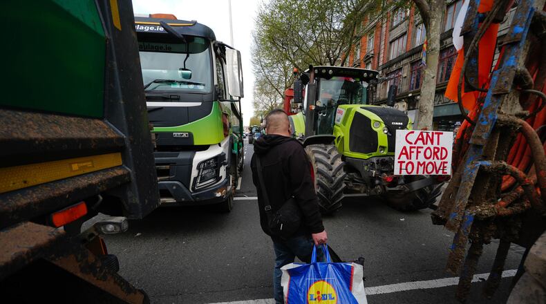 A man walks in between vehicles parked on O'Connell Street on the second day of a national fuel protest against rising fuel prices, in Dublin, Ireland, Wednesday April 8, 2026. (Brian Lawless/PA via AP)