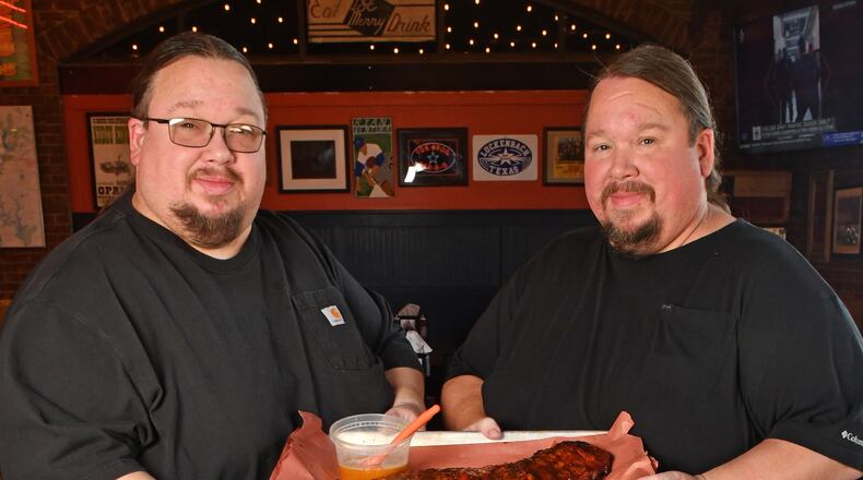 240620 Brookhaven, Ga: Brothers Justin (glasses) and Jonathan Fox, co-owners of Atlanta-based Fox Brothers Barbecue, show how to use their ÒBrookhaven Rib GlazeÓ - (note the glazeÕs title may change according to Jonathan Fox) on a rack of BBQ Baby Back Ribs at their recently opened Brookhaven location at, 4058 Peachtree Road, Brookhaven Ga. 30319. Photo for AJC Food section story on Marinades, by C.W. Cameron. Photos taken Thursday June 20, 2024. Food styling by Jonathan and Justin Fox. 071424MARINADES (CHRIS HUNT FOR THE ATLANTA JOURNAL-CONSTITUTION)