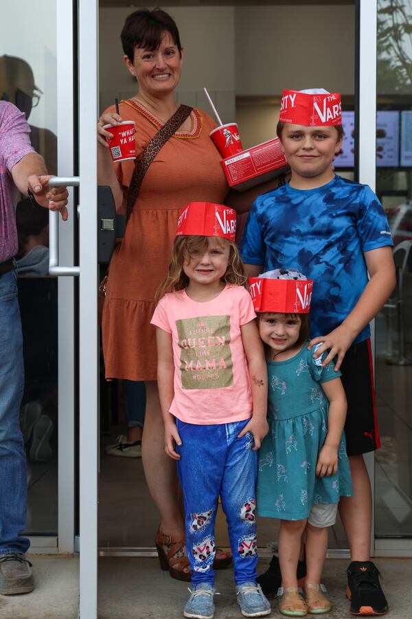 Edith Ann Parham and her children show off their Varsity gear after dinner at the new Watkinsville location of the restaurant on Thursday, April 24, 2025. Edith Ann and her husband, Kip (holding the door), drove the family from Royston after learning on social media that the new spot was open. (C.J. Bartunek for The Atlanta Journal-Constitution)

