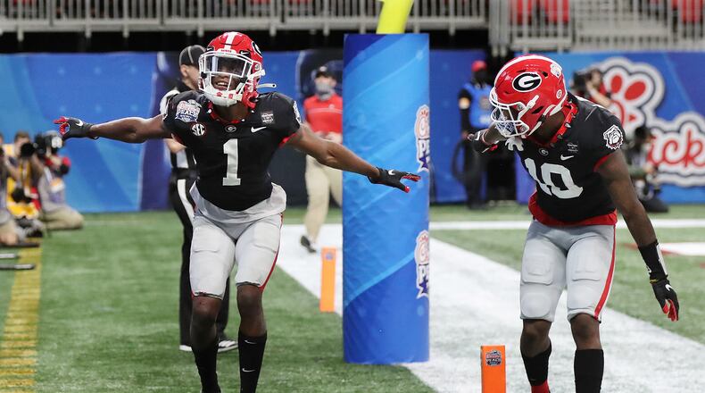 010121 ATLANTA: Georgia wide receiver George Pickens (left) celebrates his touchdown reception with Kearis Jackson to tie the game 7-7 with Cincinnati during the first quarter in the NCAA college football Peach Bowl game on Friday, Jan. 1, 2021, in Atlanta. Georgia beat Cincinnati 24-21. Curtis Compton / Curtis.Compton@ajc.com”