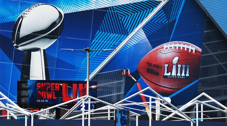 Workers use a lift to install a Super Bowl LIII wrap on the outside of Mercedes-Benz Stadium as it is transformed for the big game in Atlanta. Lowe’s, announced it is a new official sponsor of the NFL, just in time for the Super Bowl in archrival Home Depot’s hometown. Curtis Compton/ccompton@ajc.com