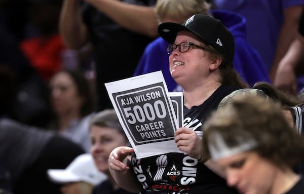 A fan holds a up a sign after Las Vegas Aces center A'ja Wilson (22) scores a basket to achieve her 5,000th career point in the WNBA during the first half of a WNBA basketball game against the Connecticut Sun, Wednesday, June 25, 2025, in Las Vegas. (Steve Marcus/Las Vegas Sun via AP)