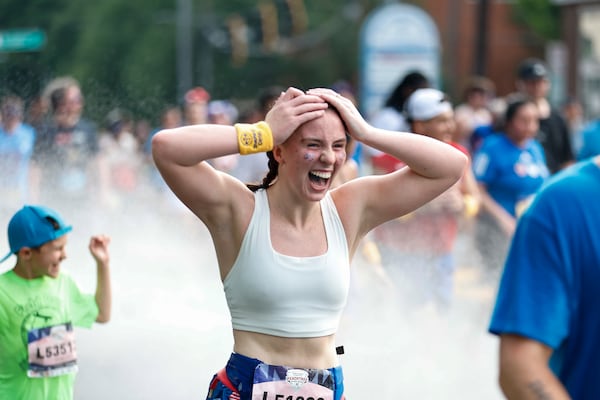 Runners celebrate completing Hope Hill during the 2026 Peachtree Road Race. (AJC)