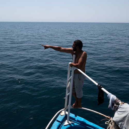 A fisherman communicates with Tunisian national guard during a search operation after a boat carrying migrants capsized off the country's southeastern coast, near Zarzis, Tunisia, Sunday, Aug. 23, 2026. (AP Photo/Bassem Aouini)