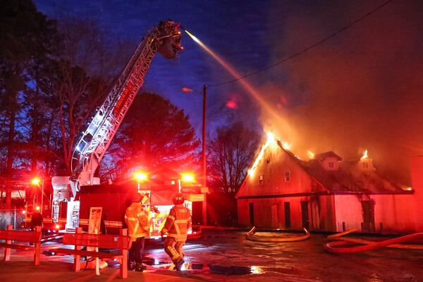 Crews worked Monday to fight a business  fire that shut down Redan Road  east of South Hairston Road in DeKalb County.  JOHN SPINK / JSPINK@AJC.COM