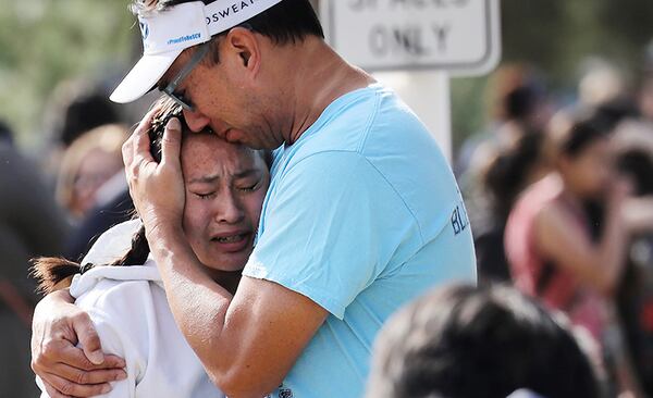 A father hugs his daughter after being reunited at a park near Saugus High School after the shooting.
