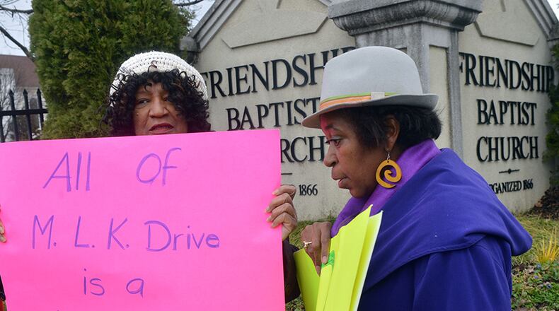 Carrie Savary (left) and Yvonne Jones joined other members of the Westside Neighborhoods Coalition at a press conference and rally at the corner of MLK Drive and Northside Drive Wednesday. Residents want more detailed plans about how the road will be rerouted when the new Falcons stadium is built.